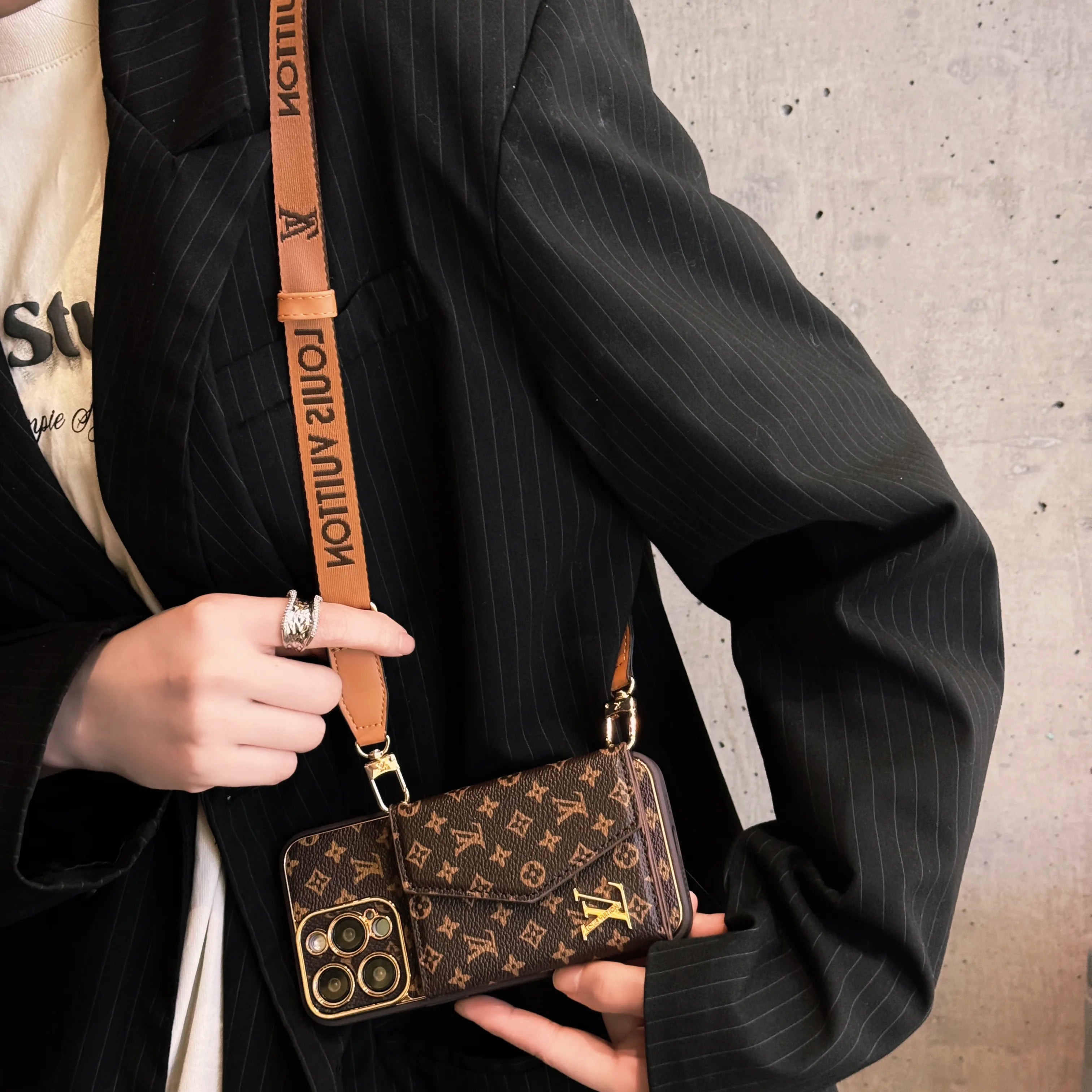 Edistyksellinen nahkainen iPhone-kotelo, jossa lompakko ja ruskea hihna