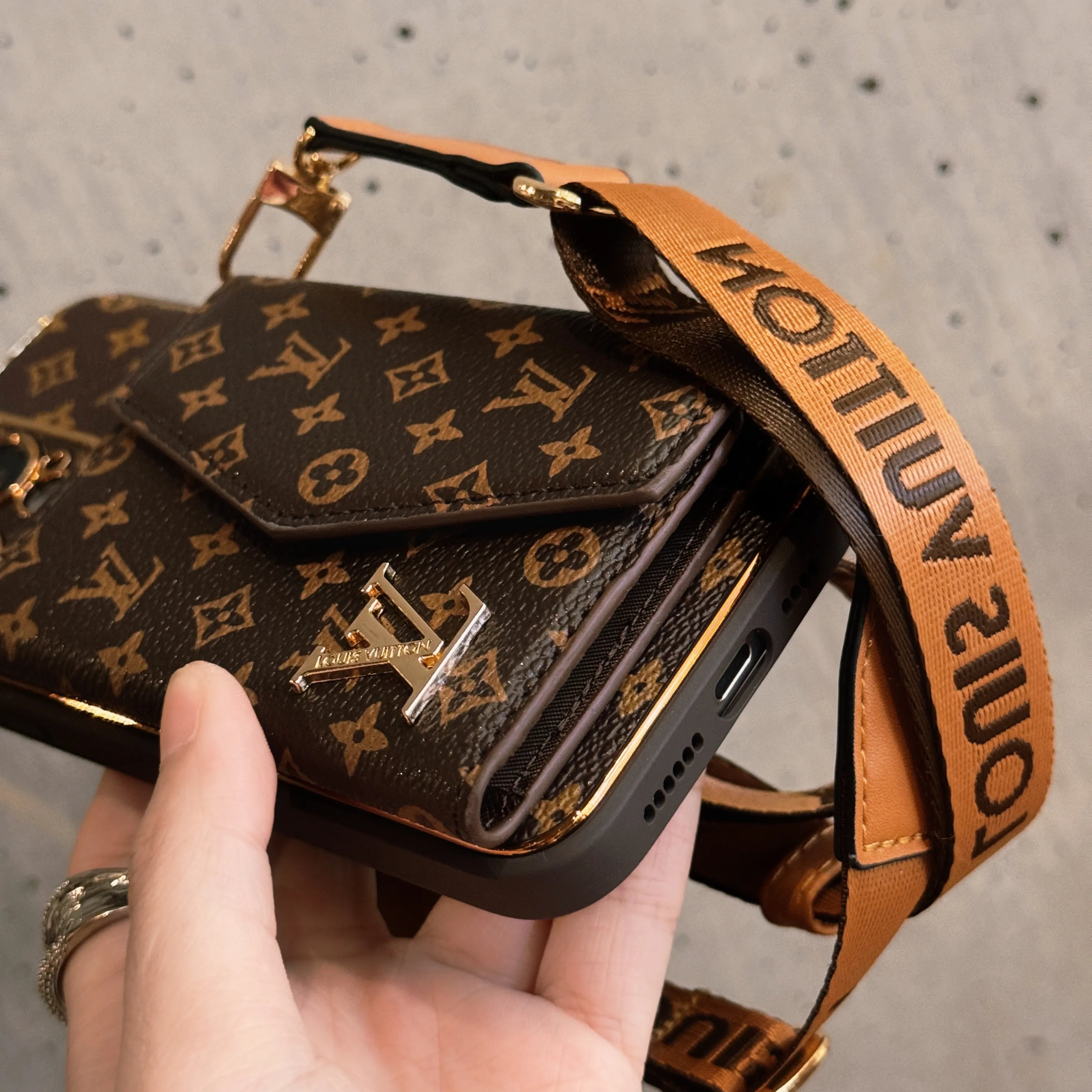 Edistyksellinen nahkainen iPhone-kotelo, jossa lompakko ja ruskea hihna